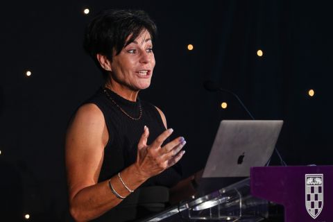 close up of Penny Mallory speaking on stage making hand gestures