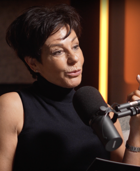 Penny Mallory speaking on a podcast, she is half smiling