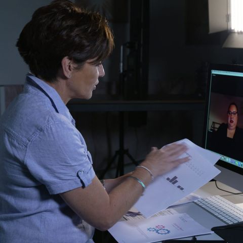 Penny Mallory virtual coaching client holding paperwork and making a hand gesture